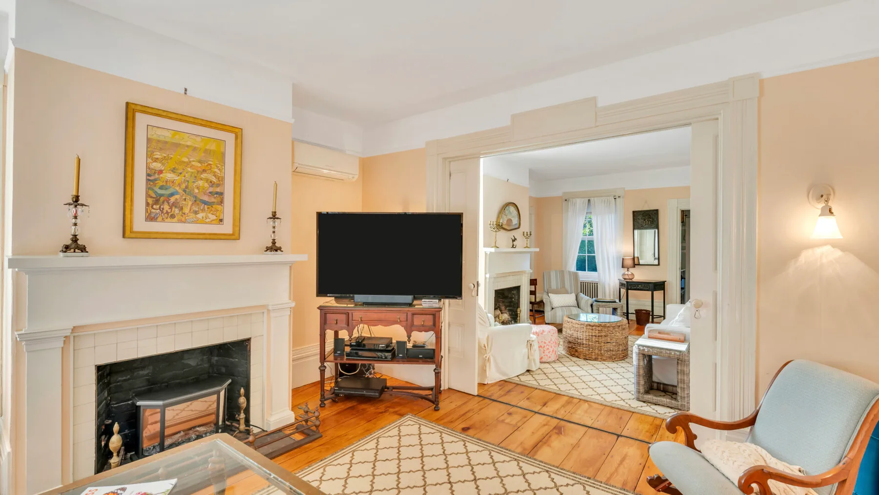 Una sala luminosa con chimenea, televisor y asientos.