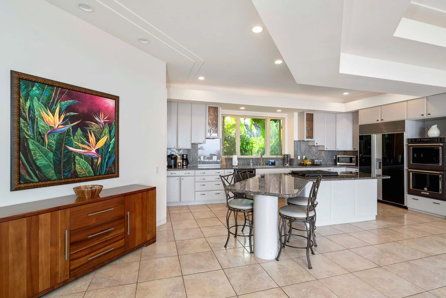 A bright kitchen with a central island and white cabinetry.