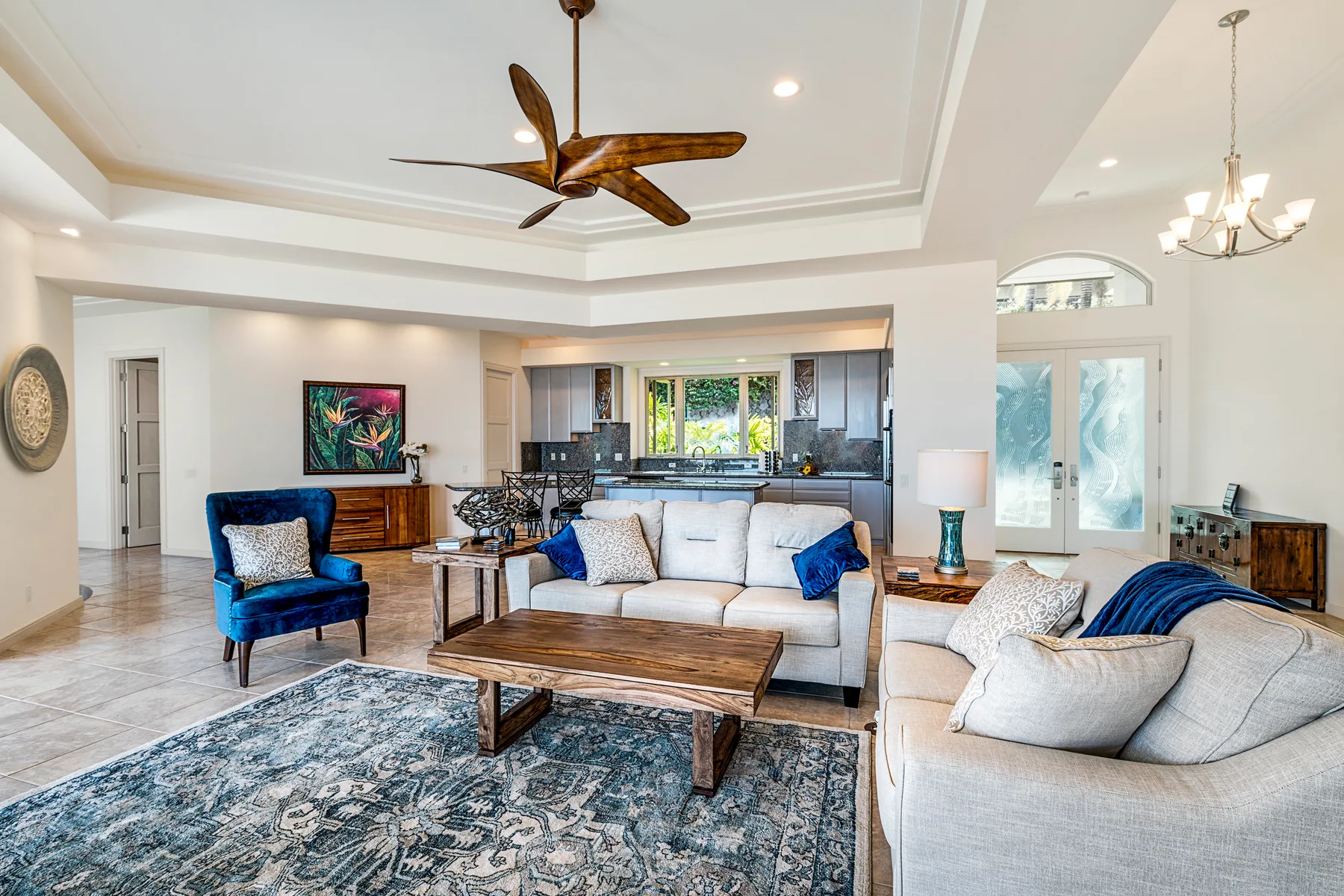 A bright living room with sofas, a coffee table, and an open kitchen.