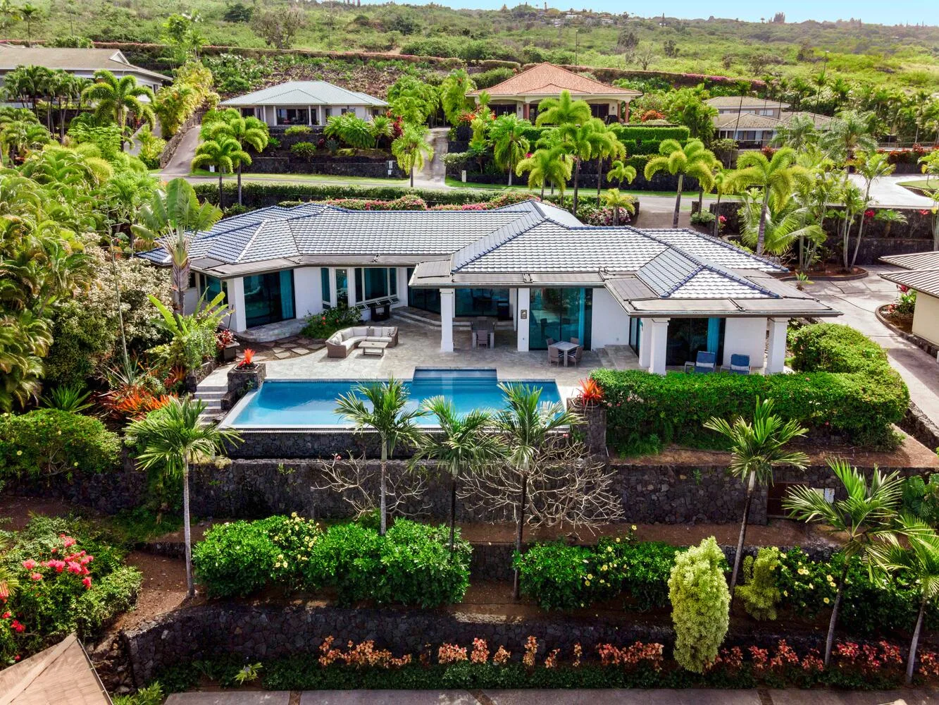 A landscaped residential property with a swimming pool beside the home.