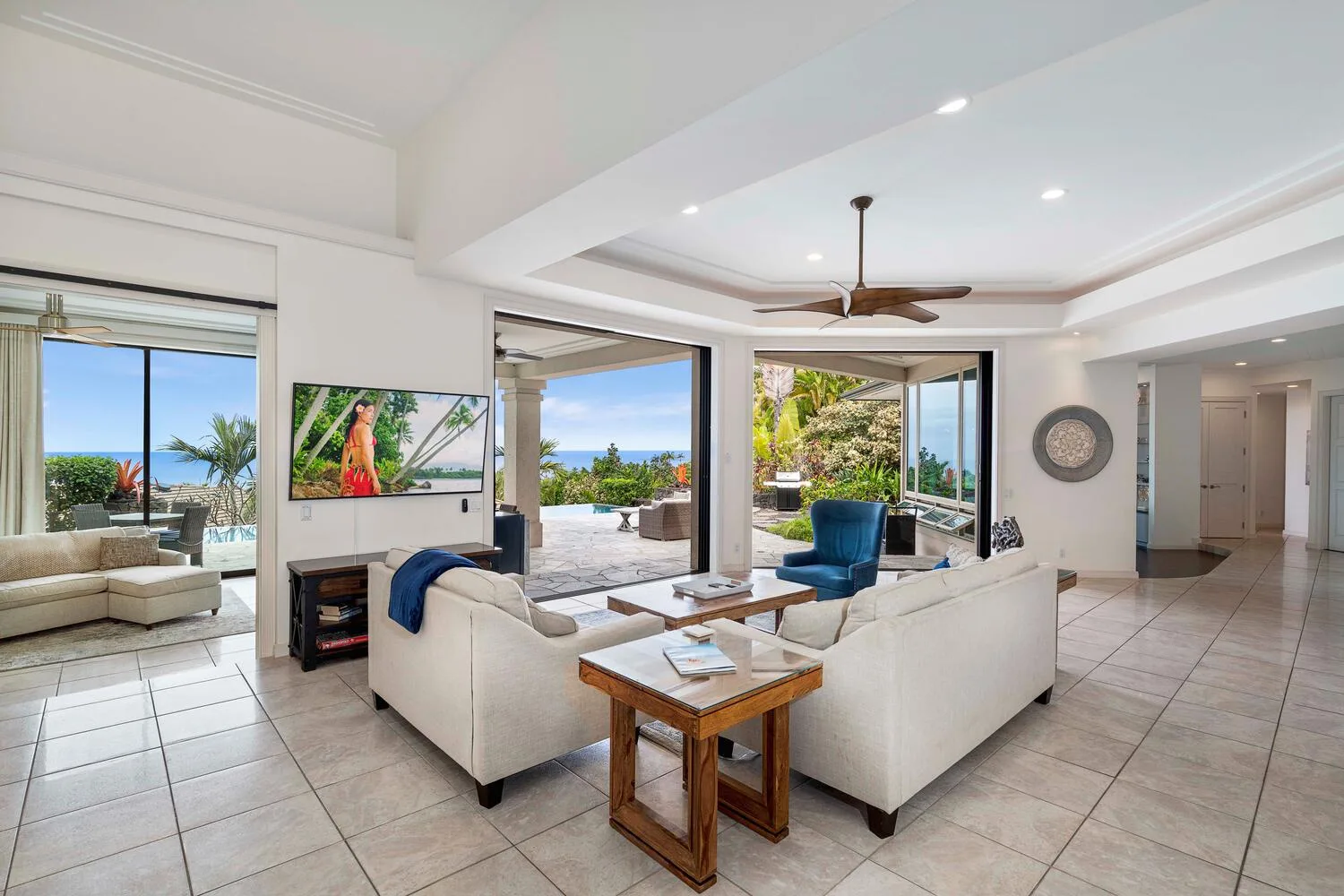 A bright living room with seating arranged around a coffee table and open views outside.