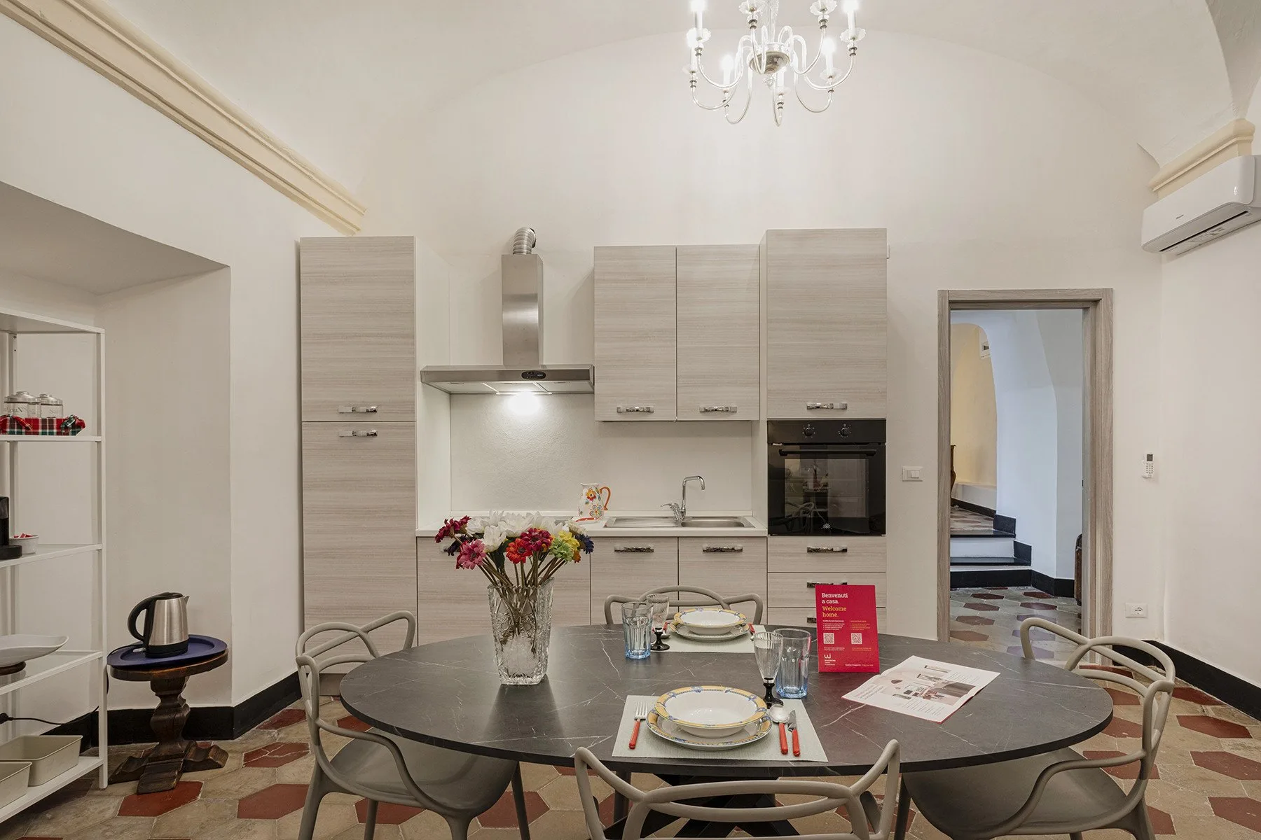 A kitchen and dining area with a table set with plates and glasses.
