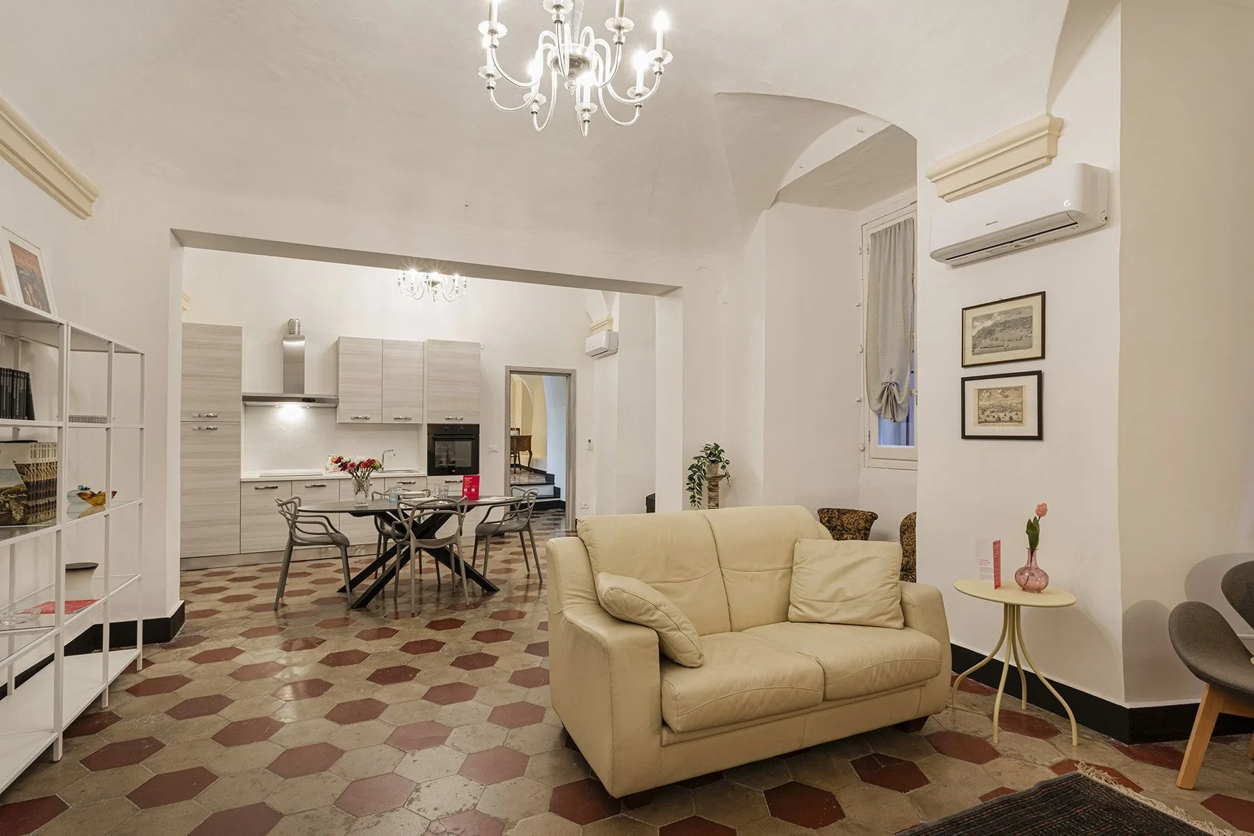A bright open-plan living room and kitchen with a dining table and seating.