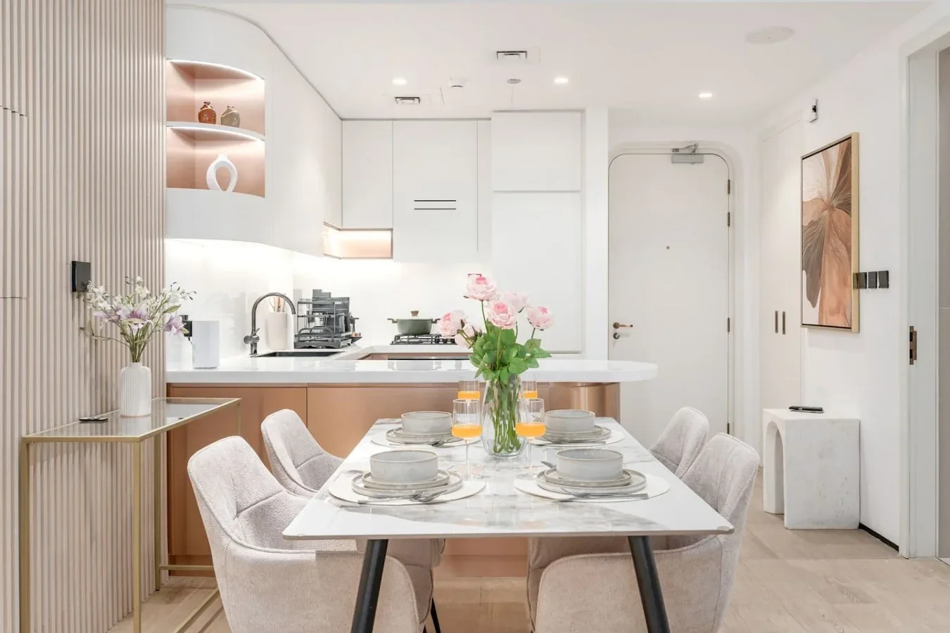 Un comedor luminoso con una mesa y sillas junto a una cocina moderna.