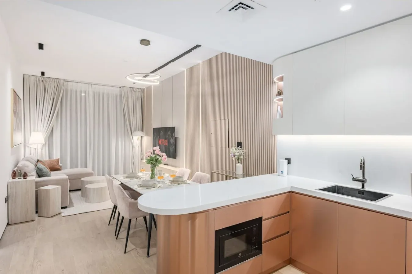 Cocina y comedor modernos de planta abierta, con una mesa junto a la sala de estar.
