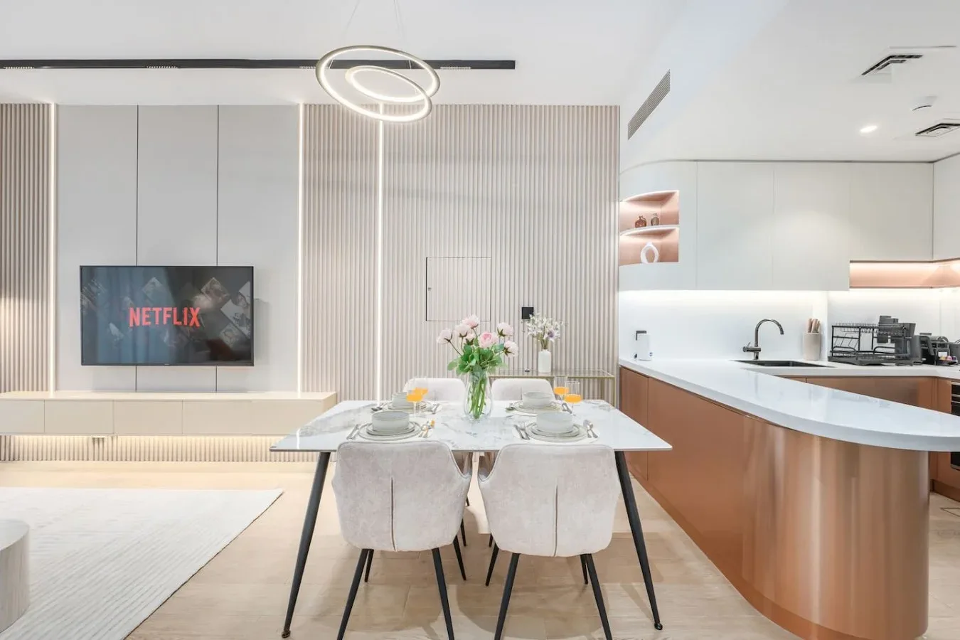 Un comedor luminoso con una mesa puesta junto a una cocina moderna.