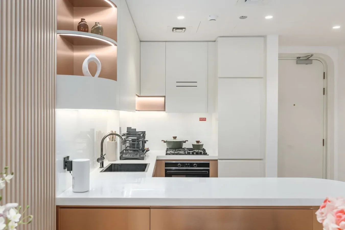 Una cocina moderna y luminosa con una isla blanca y zona de cocción integrada.