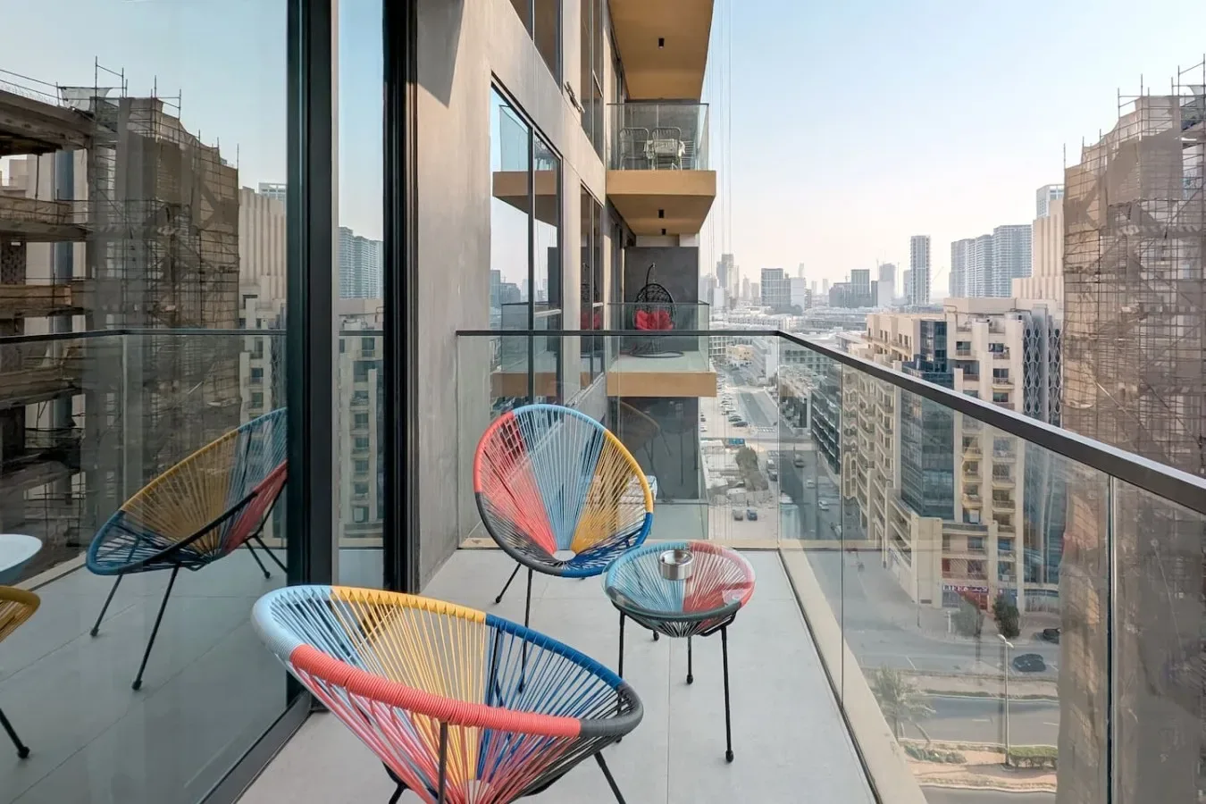 Un balcón con asientos coloridos al aire libre ofrece vistas del horizonte urbano.