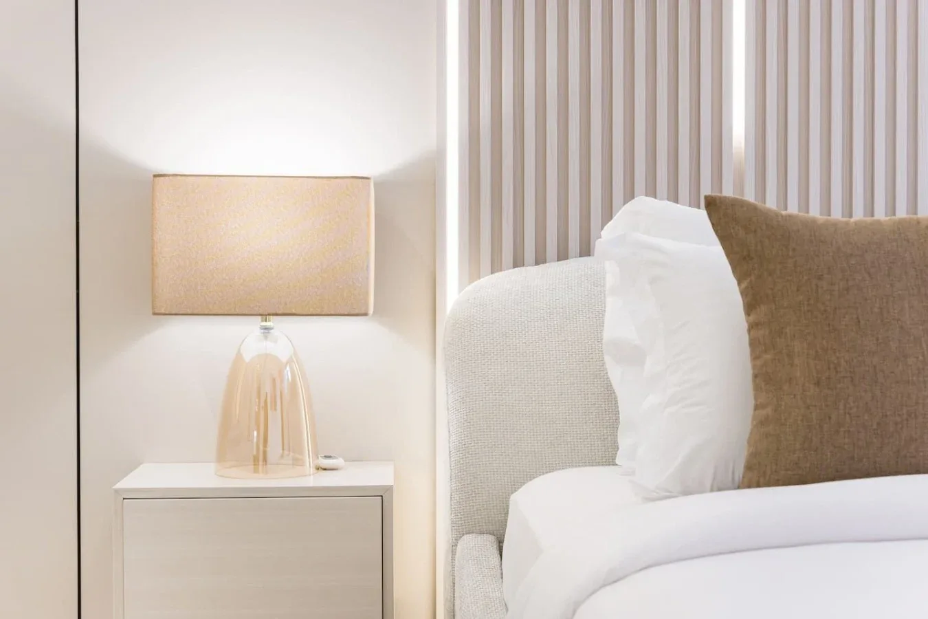 Dormitorio con una lámpara junto a la cama y las almohadas.