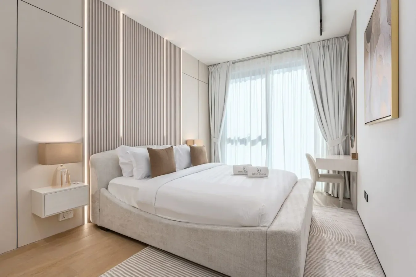 Un dormitorio luminoso con una cama bien tendida y cortinas frente a la ventana.