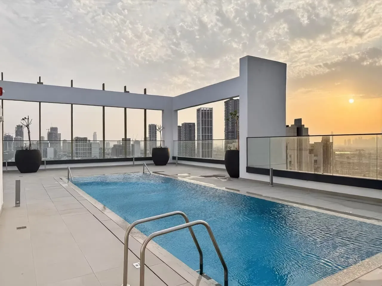 Una piscina en la azotea ofrece vistas del horizonte urbano al atardecer.