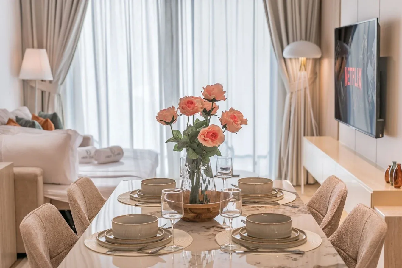 Un comedor con una mesa puesta junto a una ventana luminosa.