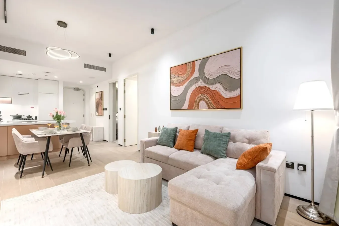 Una sala luminosa con sofá seccional, mesa de centro y comedor contiguo.