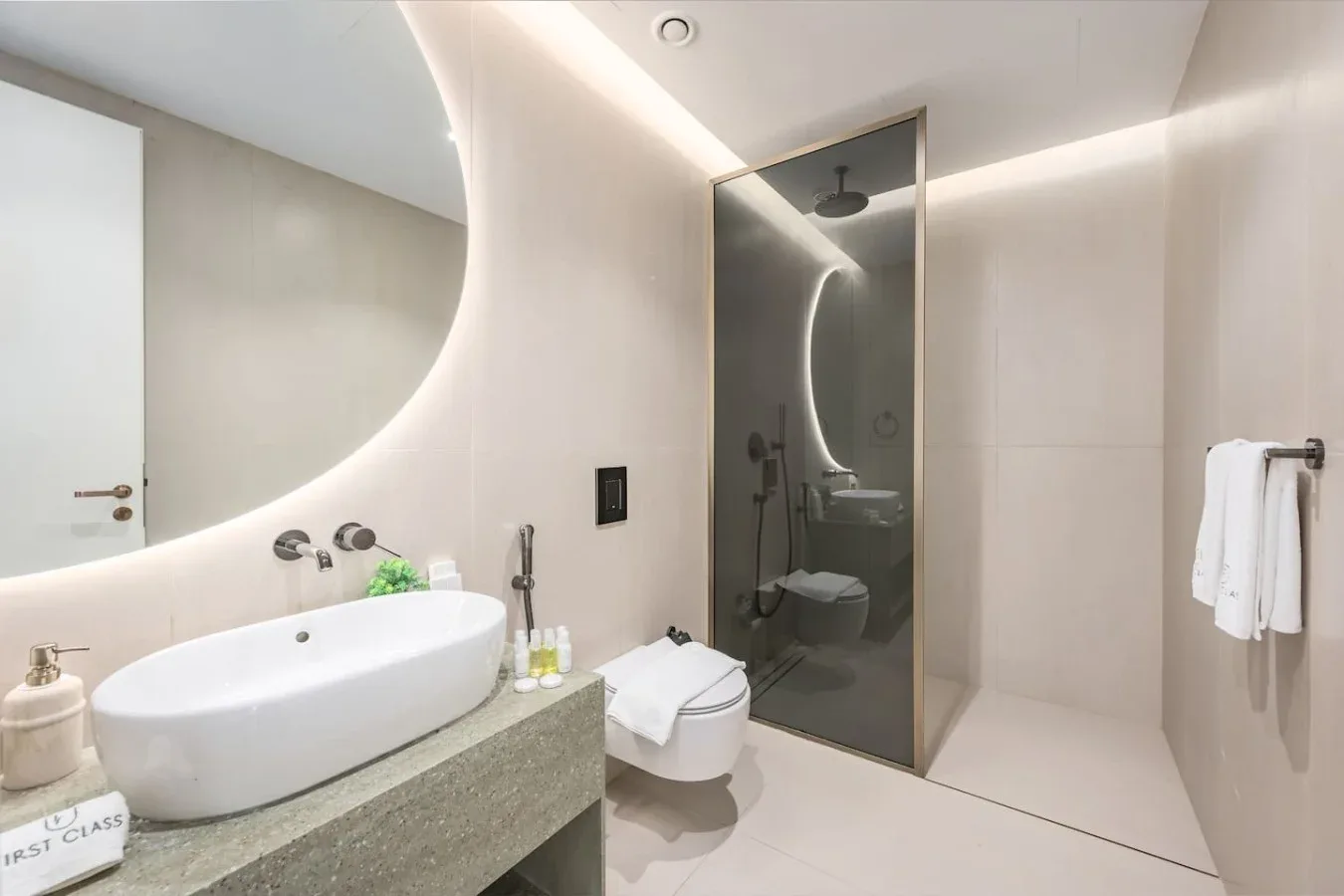 Un baño moderno con un lavabo amplio, inodoro y ducha de vidrio.