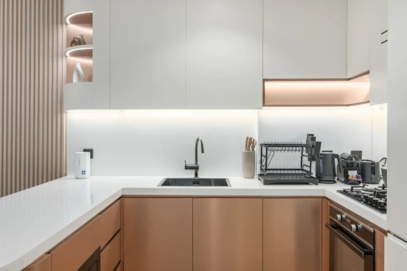 Una cocina moderna con fregadero, encimera y electrodomésticos de cocina.