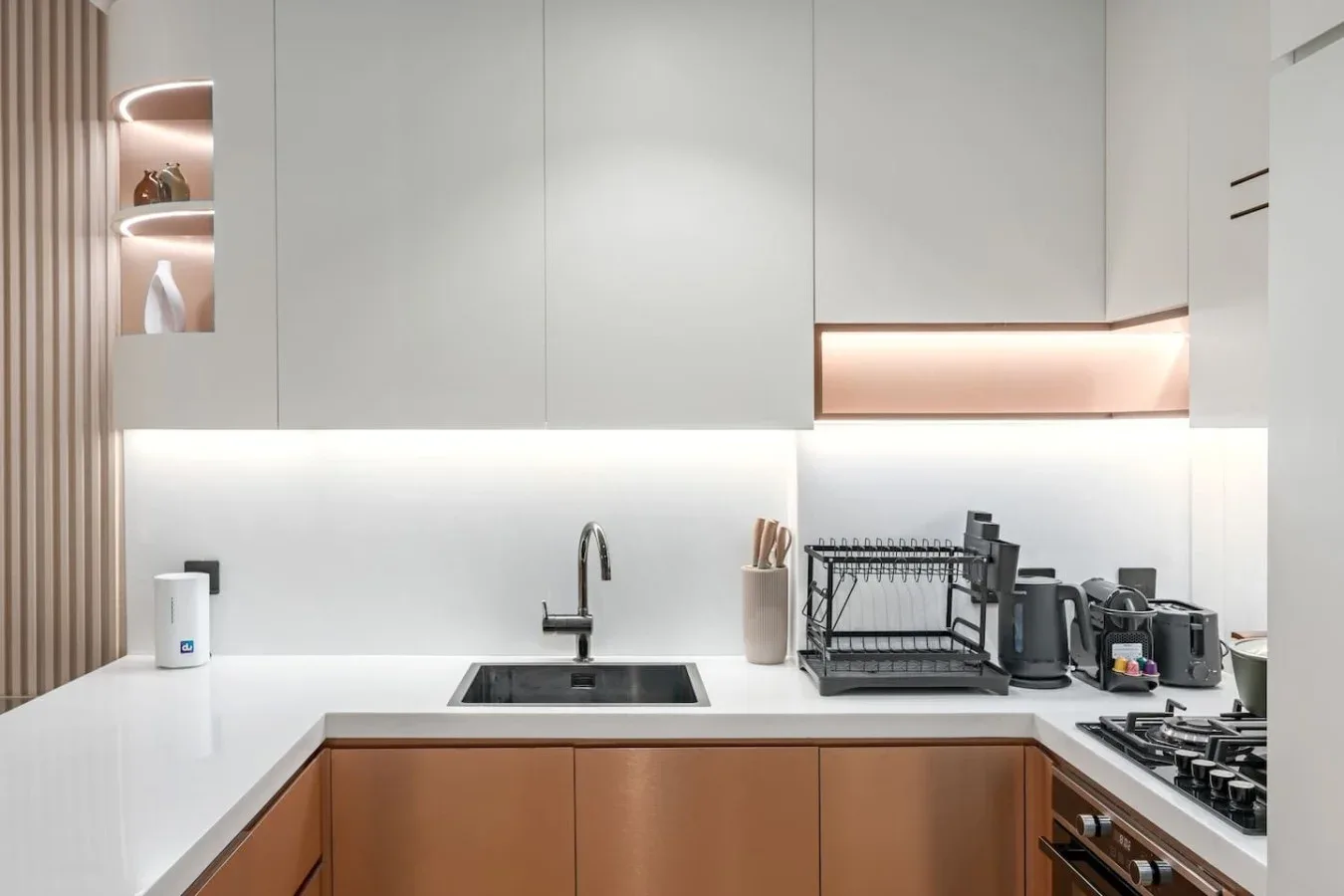 Una cocina moderna con gabinetes blancos, una encimera y electrodomésticos.