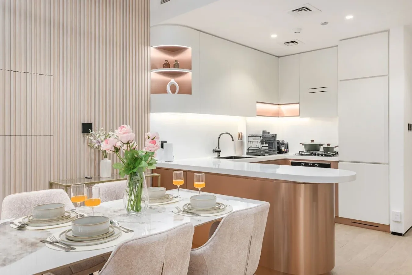 Cocina y comedor modernos, con una mesa puesta con platos y flores.