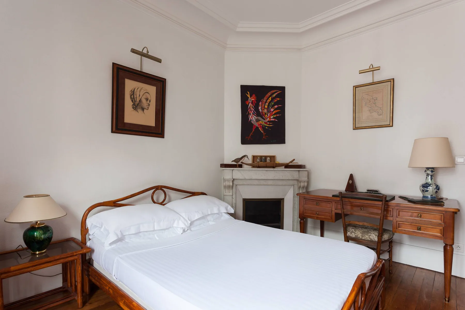 A bedroom with a wooden bed, a fireplace, and a desk.