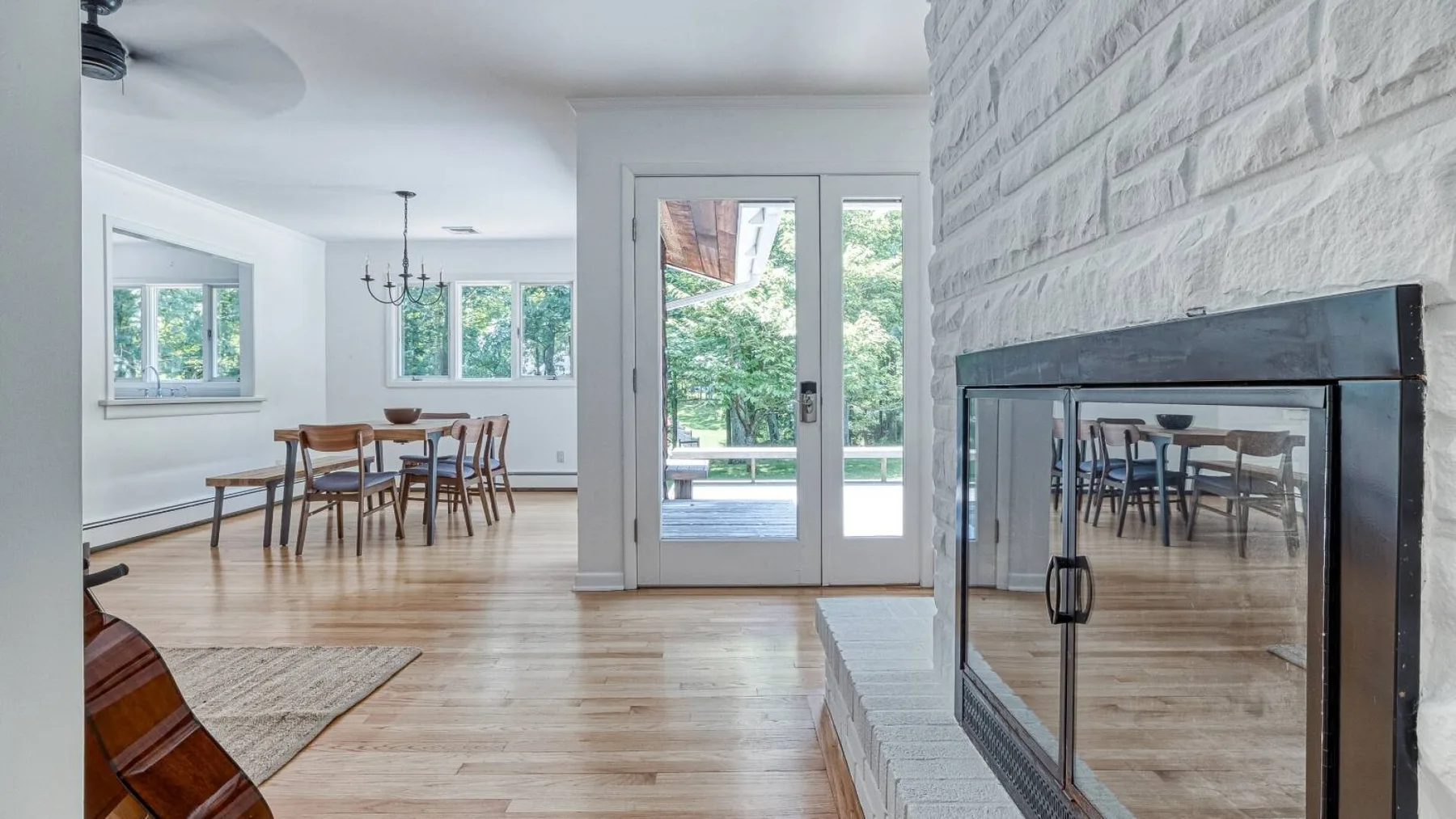 A bright dining area opens onto a patio, with a fireplace in the foreground.