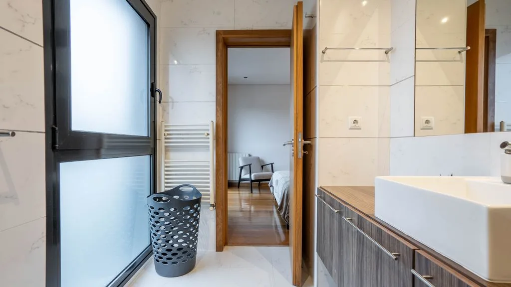 A bright bathroom with a vanity and a frosted-glass window.