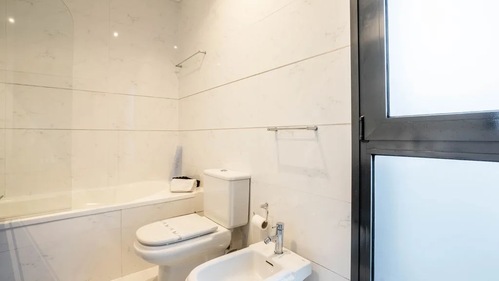 A bright bathroom with a bathtub, toilet, and sink.