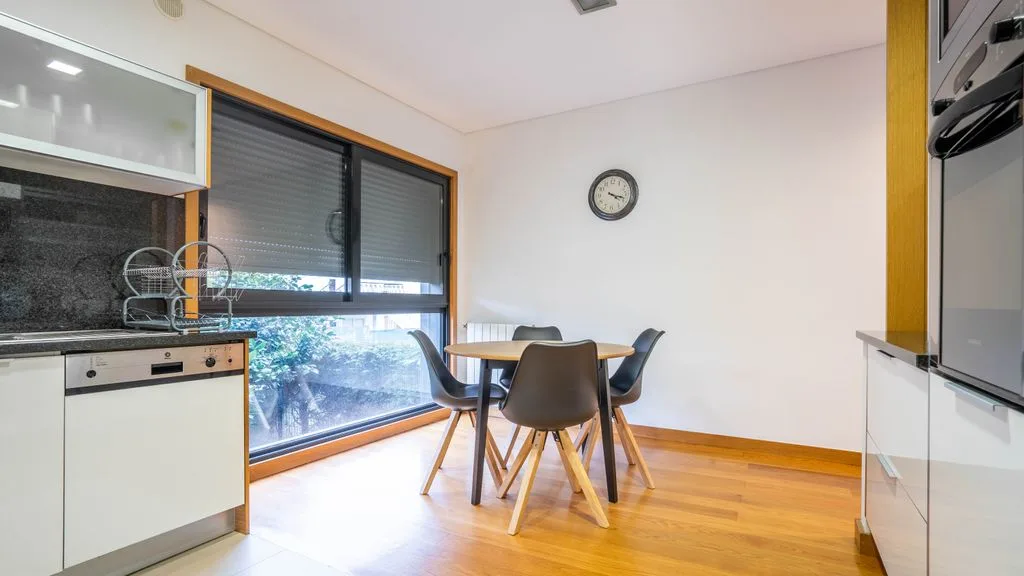 Un comedor con una mesa y sillas junto a una ventana grande.