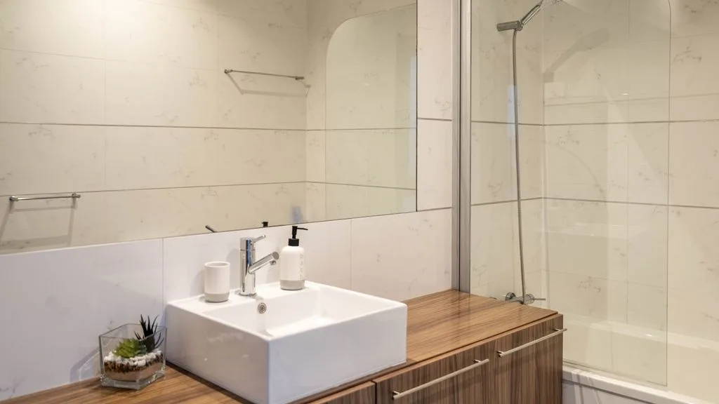 A bathroom with a sink vanity and glass shower.