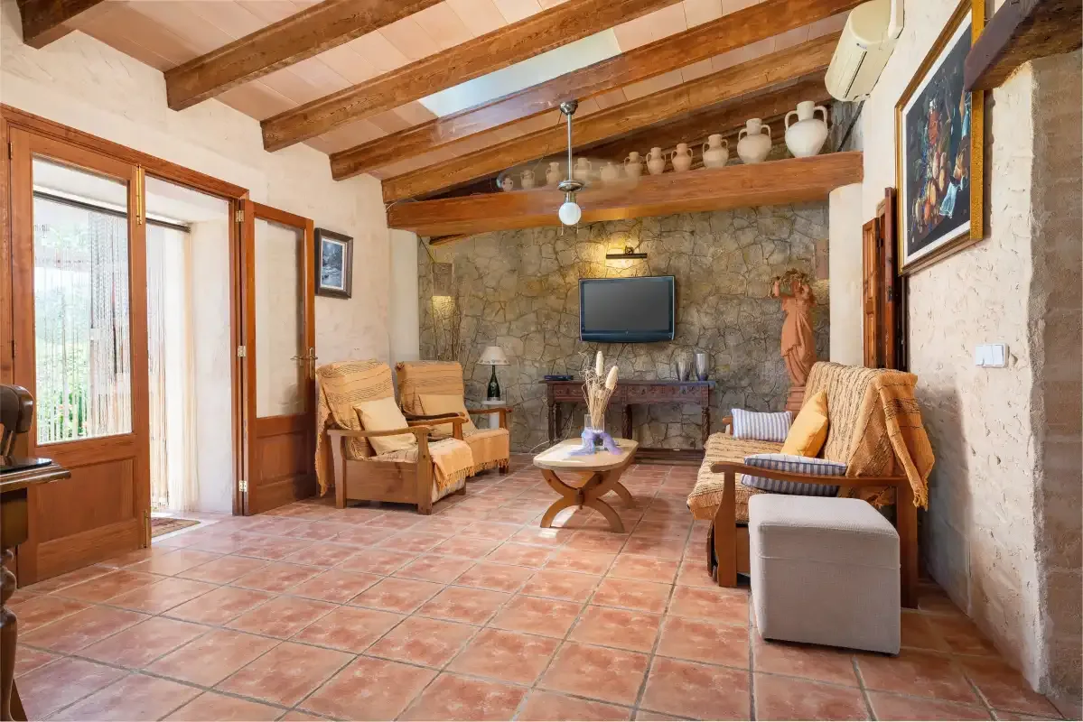 A rustic living room with seating arranged around a television.
