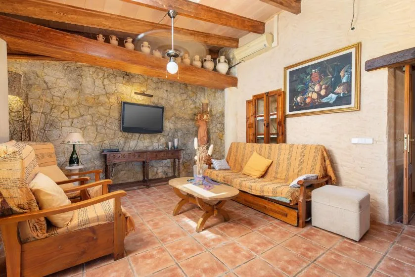 A rustic living room with seating arranged around a low coffee table.
