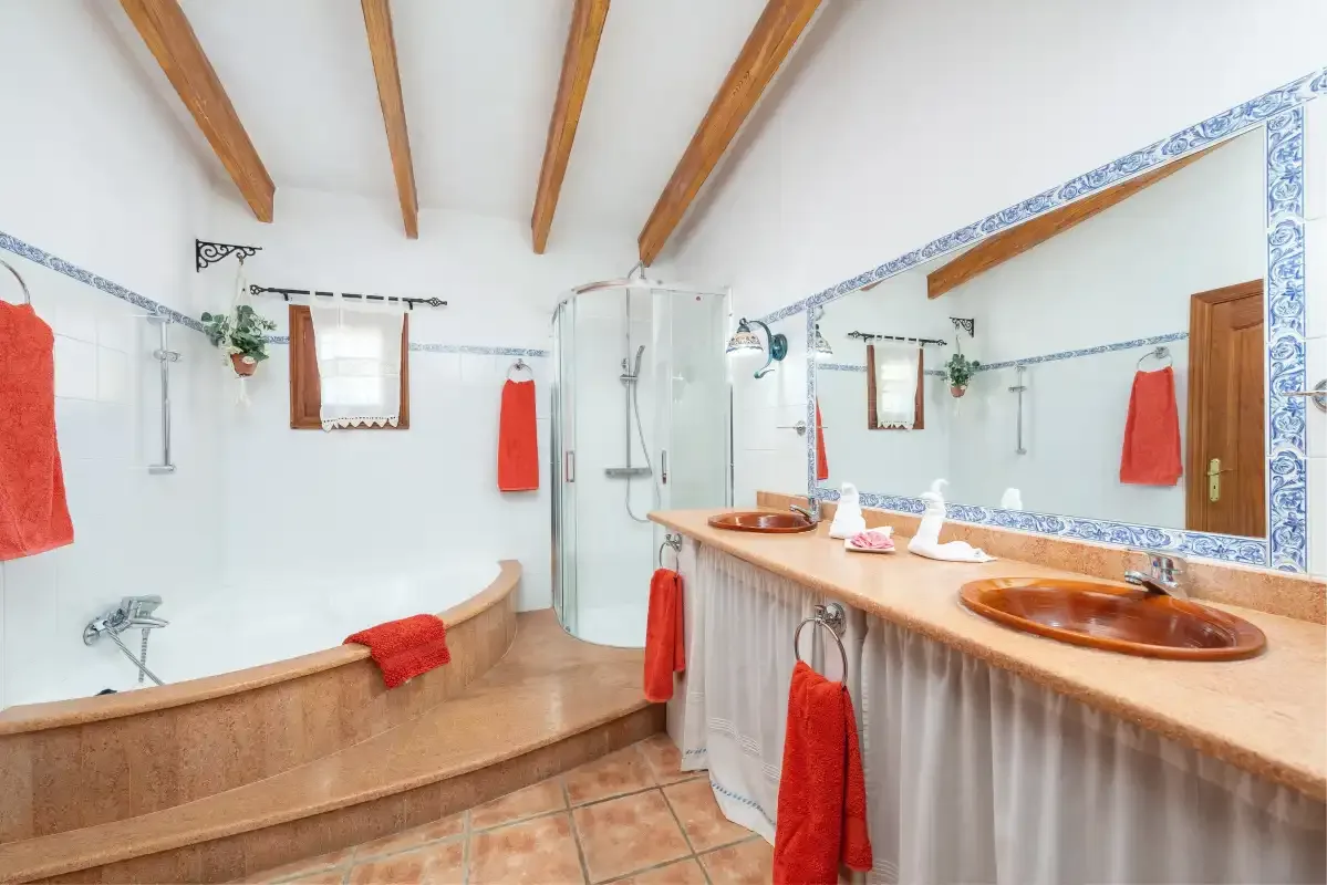 A bathroom with a long countertop, sinks, and a shower.
