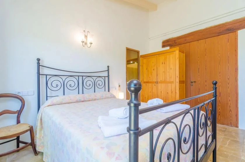 A bedroom with a metal bed frame and wooden doors.