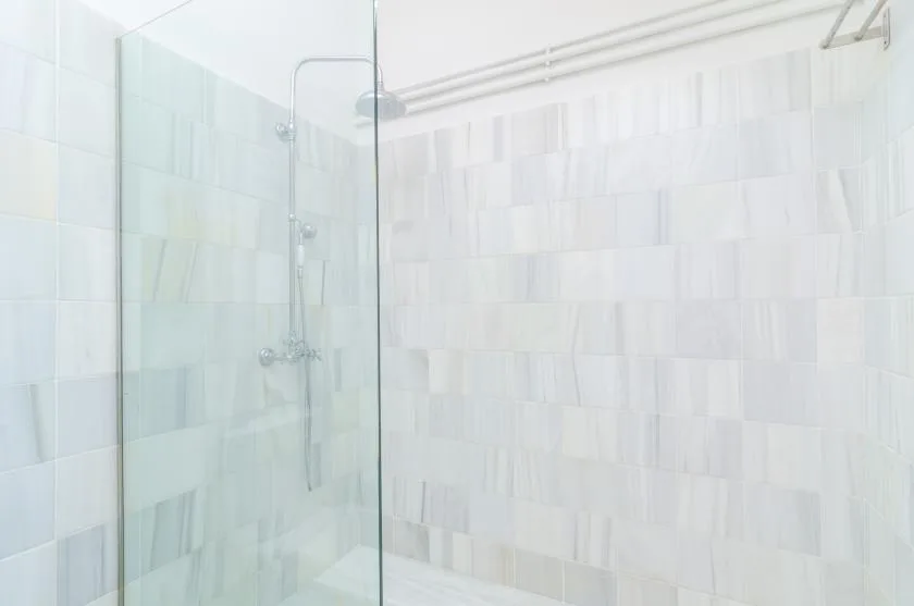 A tiled shower with a glass screen and wall-mounted shower fixtures.