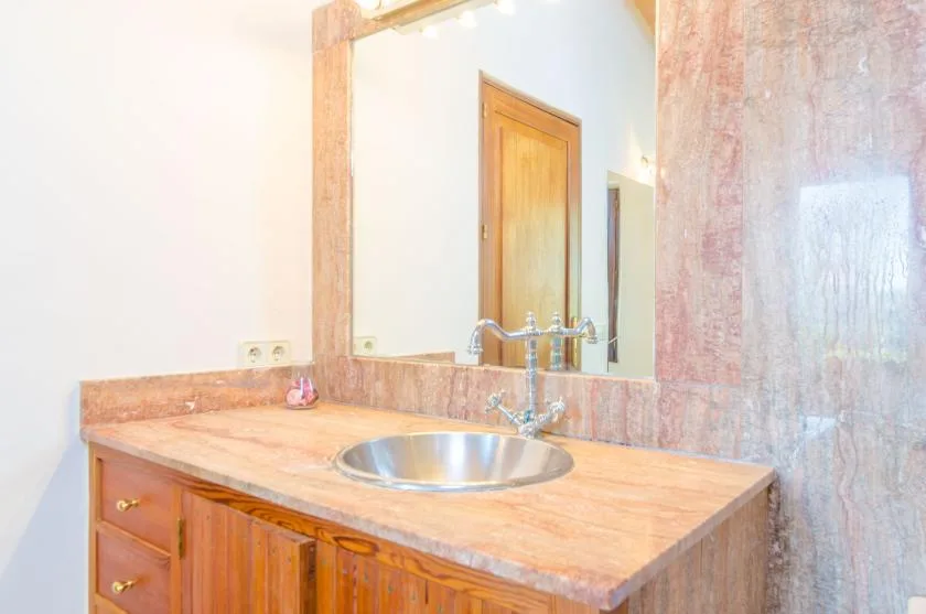 A bathroom vanity with a sink and a large mirror.