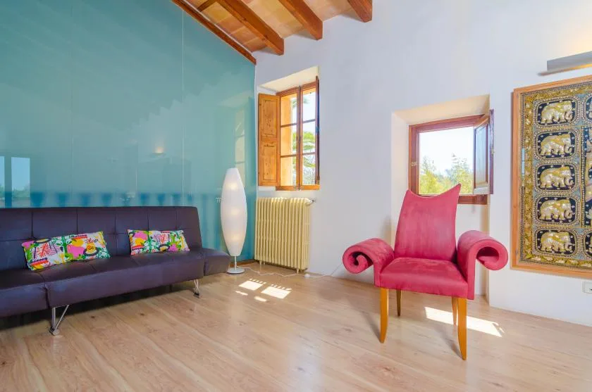 A bright living room with seating beside tall windows.