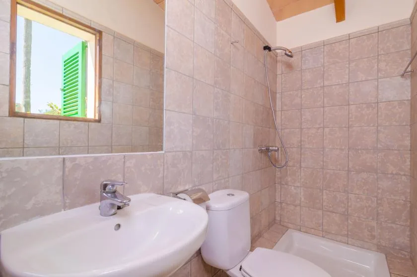 A tiled bathroom with a sink, toilet, and shower.
