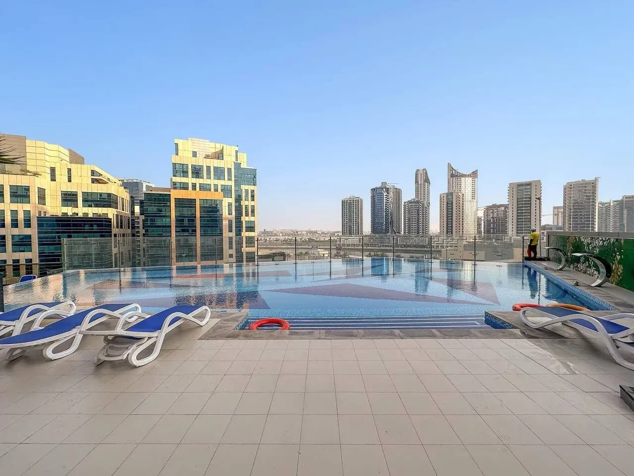 Una piscina en la azotea ofrece vistas de varios edificios altos.
