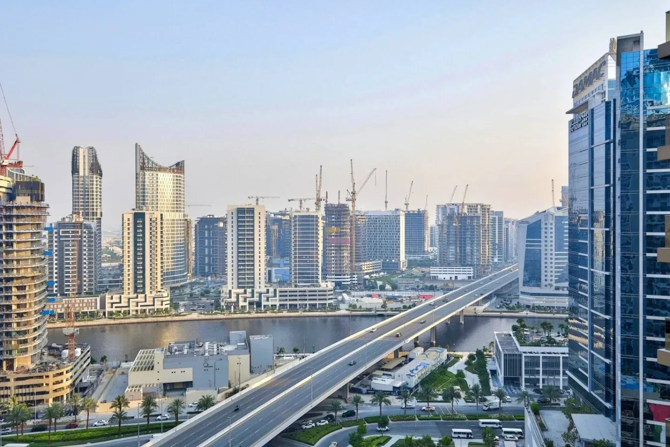 A city skyline with modern buildings and an elevated roadway.
