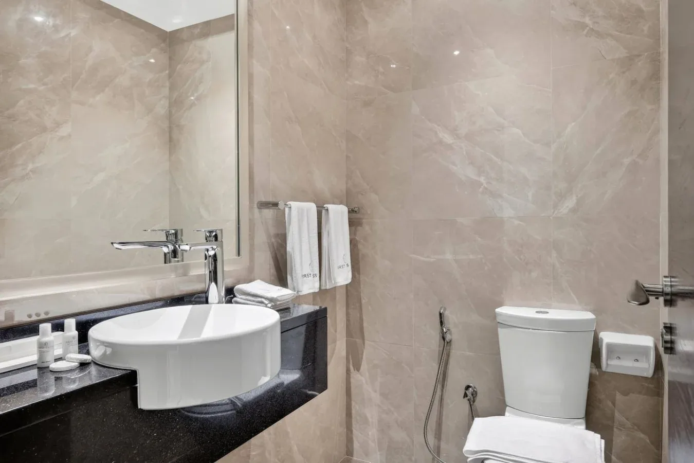 Un baño con lavabo, inodoro y toallas.
