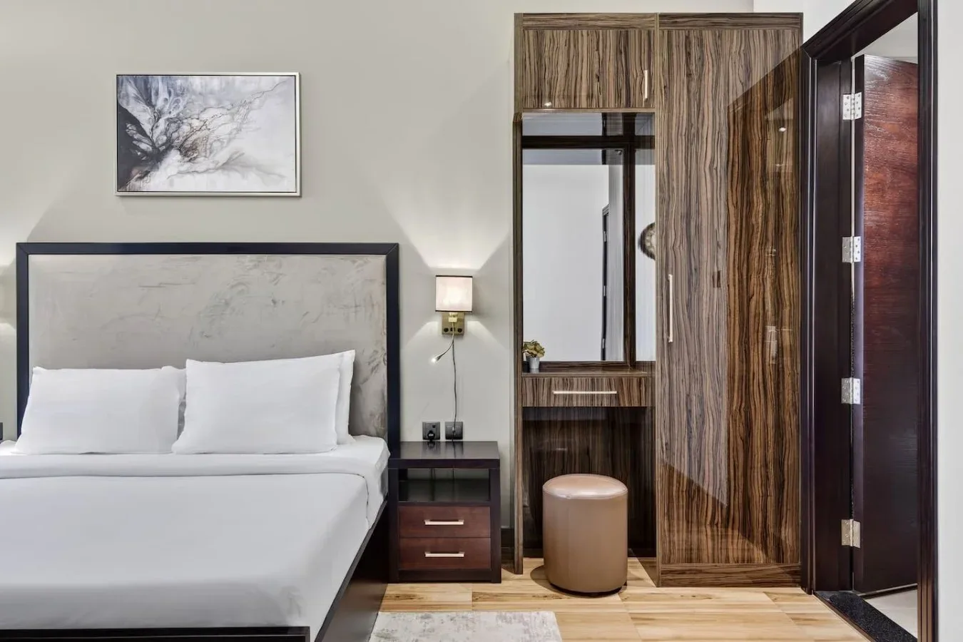 Un dormitorio con cama, mesita de noche y armario con acabado de madera.