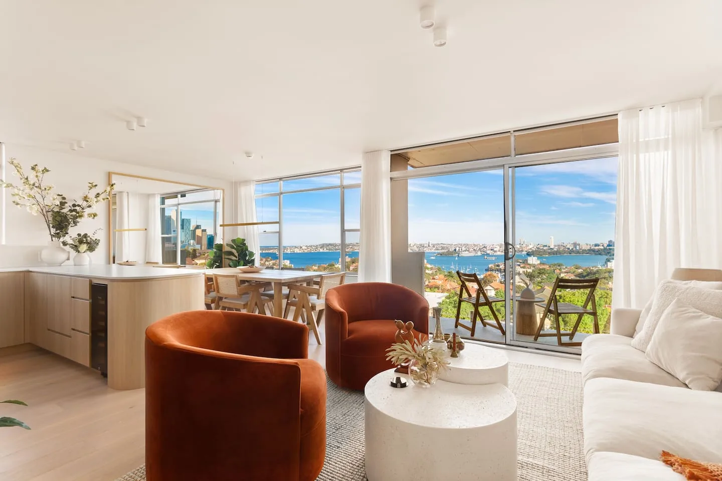 Una sala de estar luminosa con asientos y vistas al puerto a través de grandes ventanales.