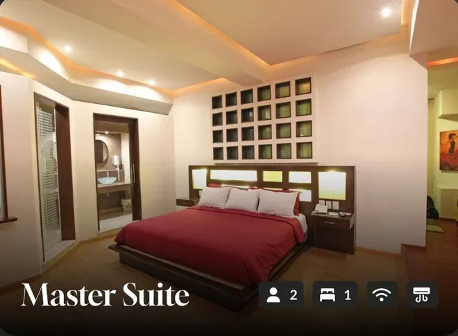 Master suite with a king bed, warm lighting, and wall art.
