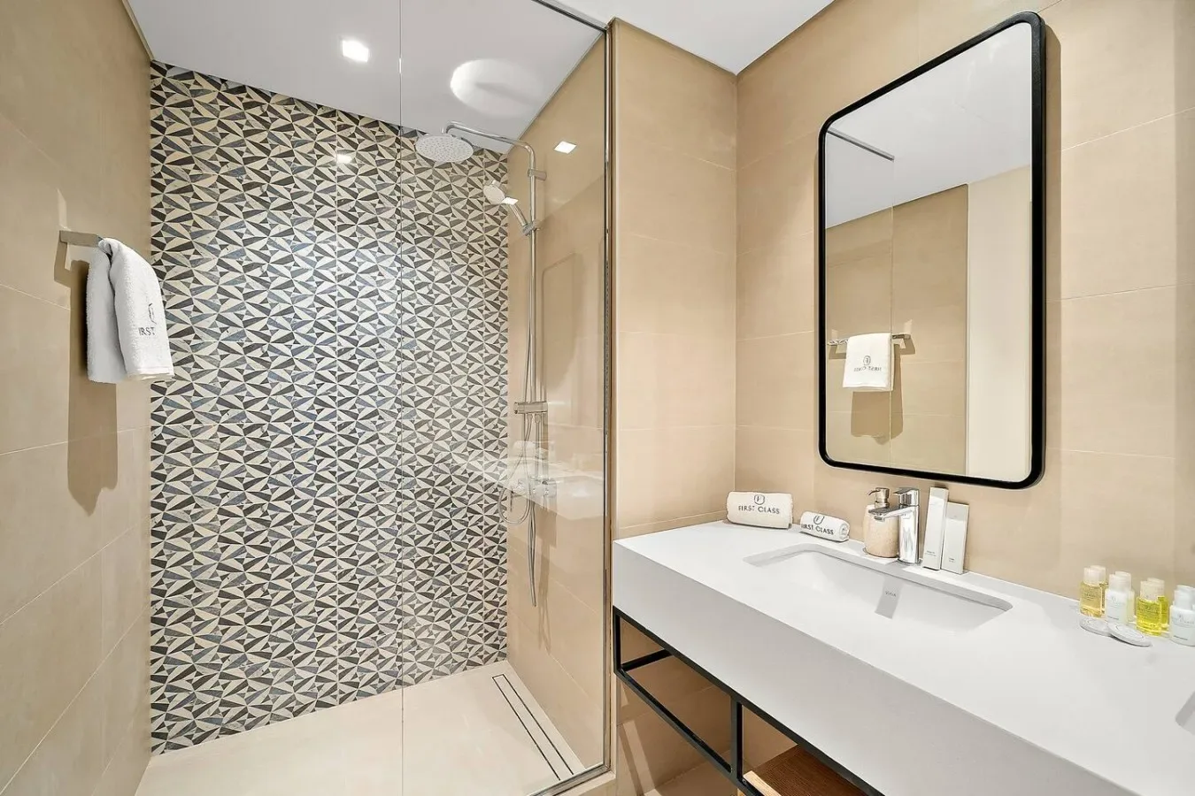 Un baño moderno con una pared de ducha estampada y un tocador largo.