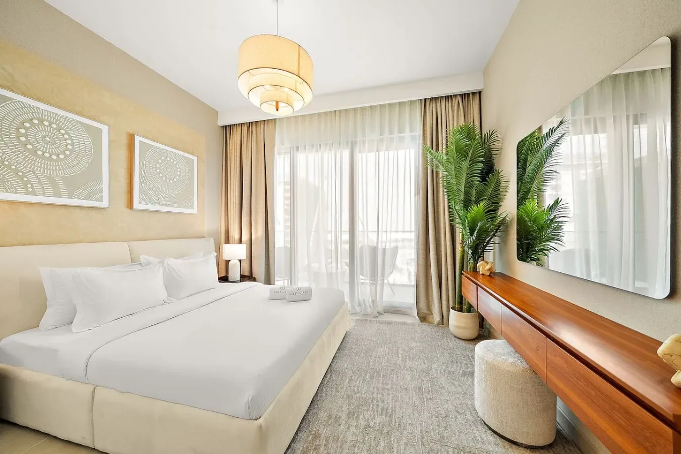A bright bedroom with a bed, large windows, and a potted plant.
