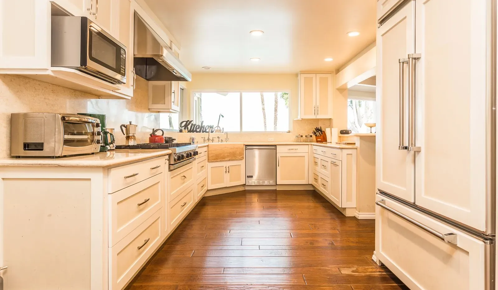 Una cocina luminosa con gabinetes blancos y una zona de trabajo central.