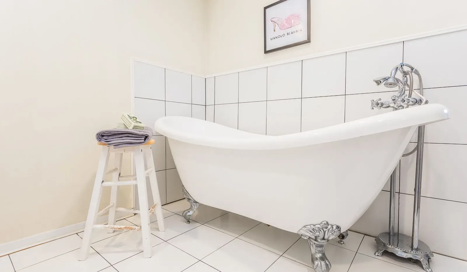 Una bañera exenta está junto a una pared alicatada en un baño.