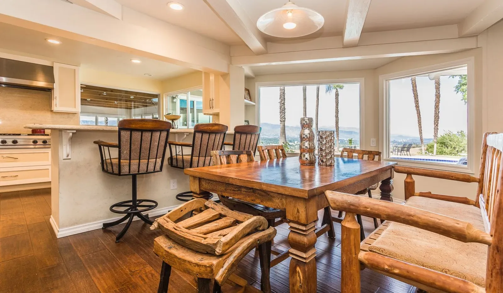 Comedor con una mesa de madera y grandes ventanales con vista al agua.