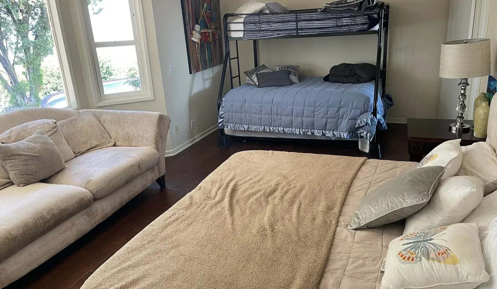 Un dormitorio con una litera, un sofá y una cama en primer plano.
