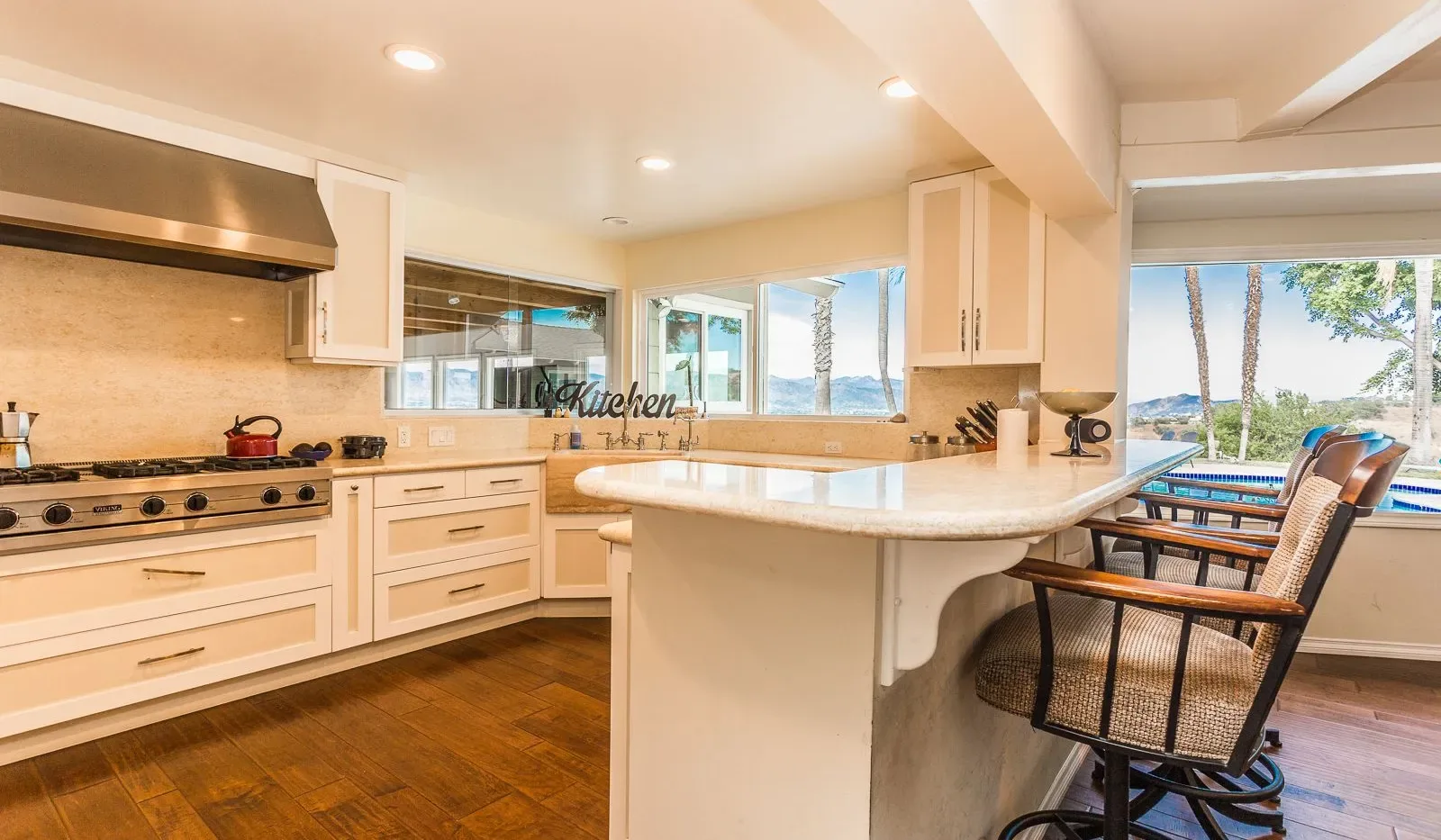 Una cocina luminosa con una encimera central y ventanas con vistas al agua.