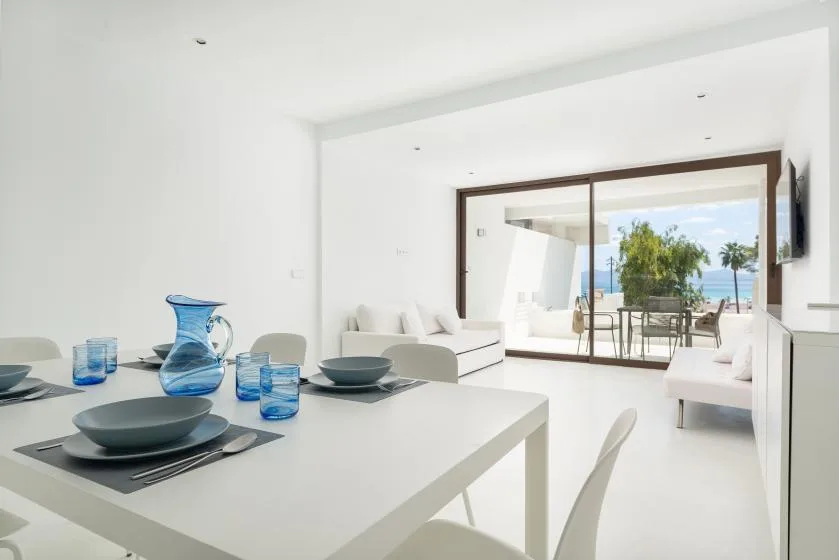 A bright dining area opens into a living space with glass doors to a patio.