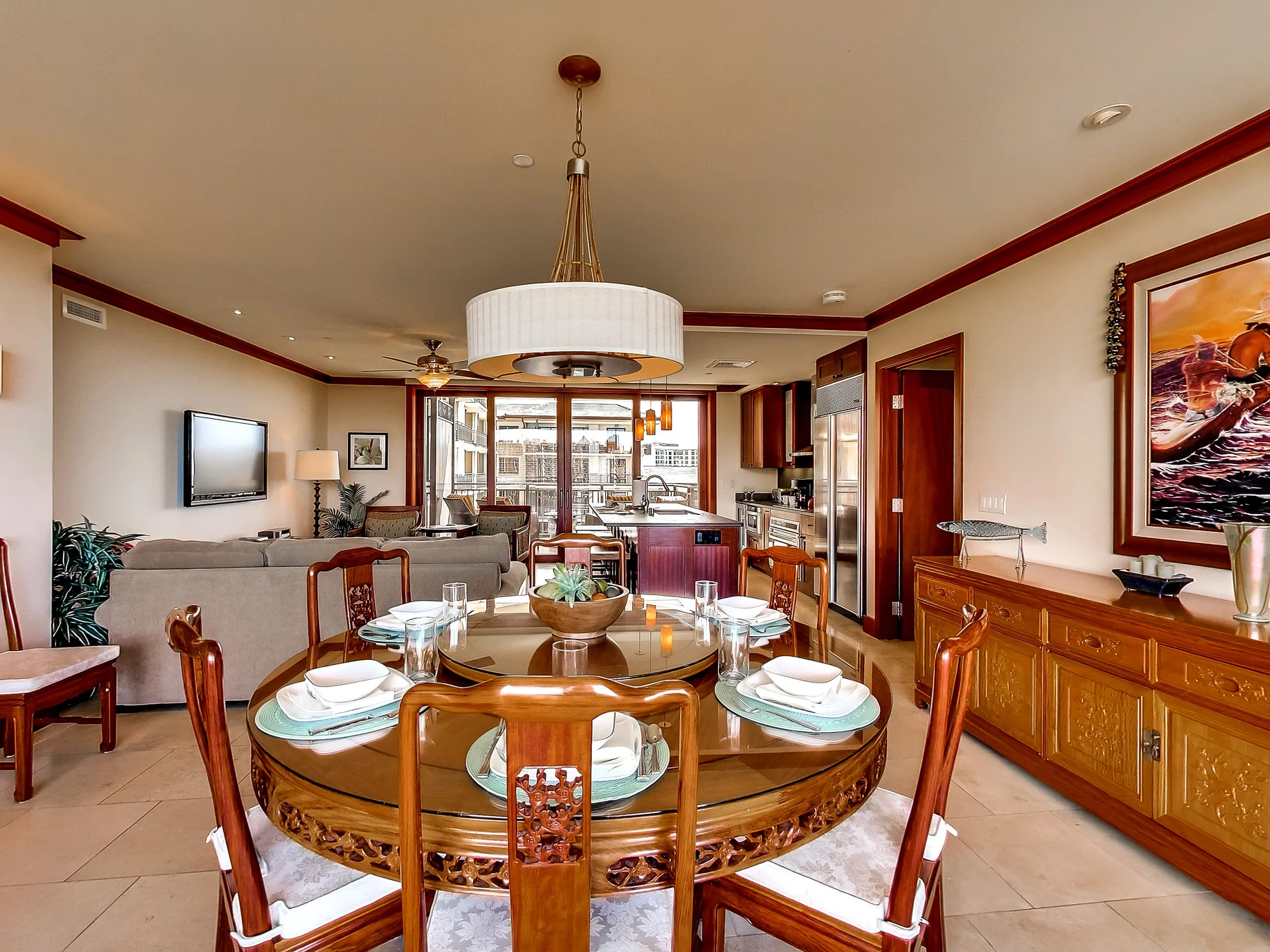 A dining area with a round table and seating, opening onto a living room.